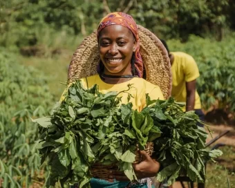 A very happy farmer coming out of the farm with some produce - Agrosahas International