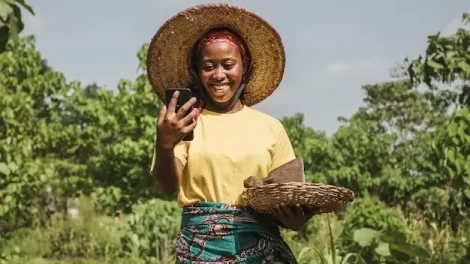 Smiling digi farmer coming from her farm with some harvest