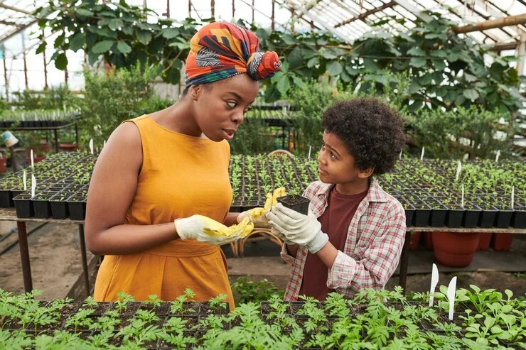 woman teaching boy plant seedlings garden
